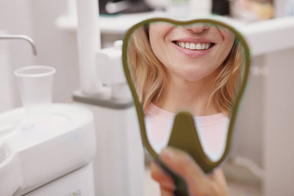 Ein schönes Lächeln in einem Dentalspiegel